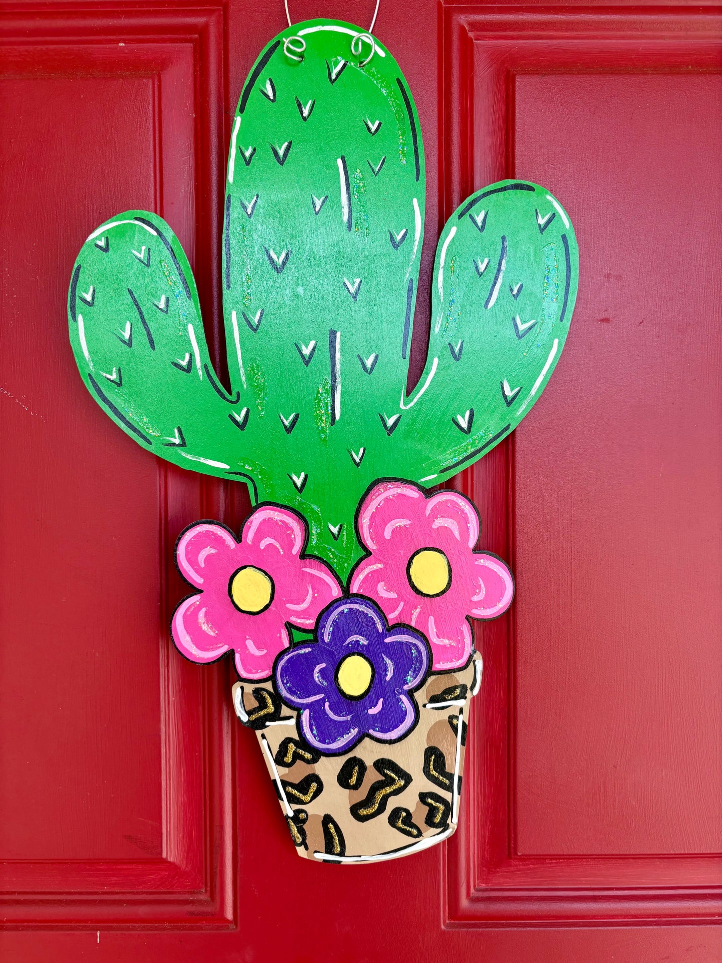 Cactus with flowers door sign.