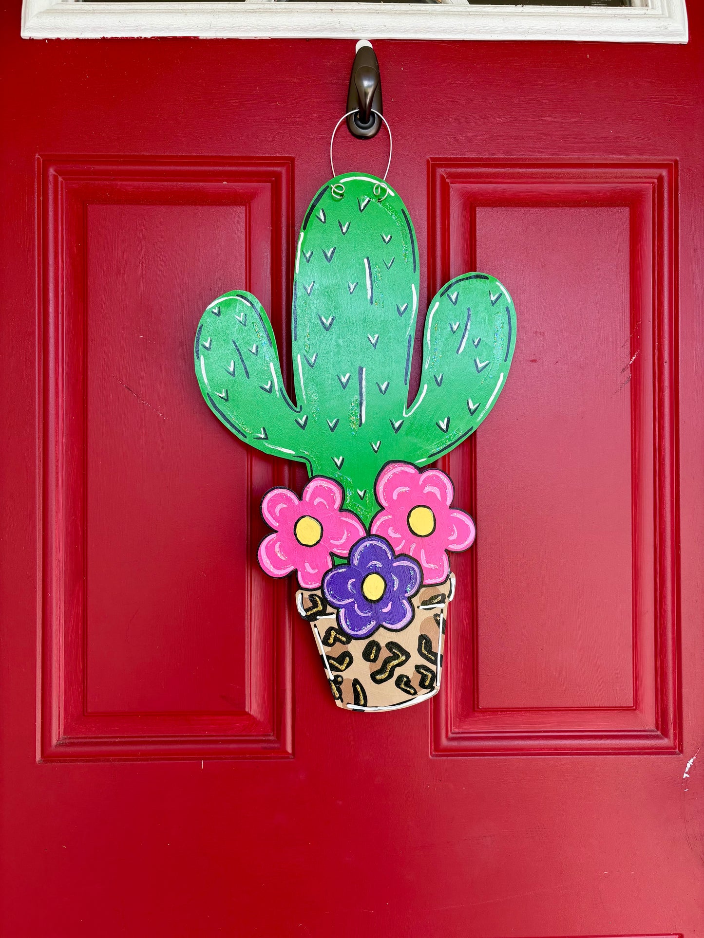 Cactus with flowers door sign.